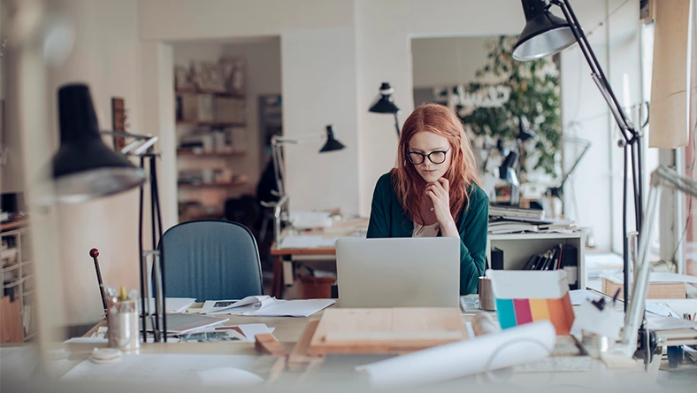 Freelancer working on a laptop while managing finances, representing retirement planning for gig workers.