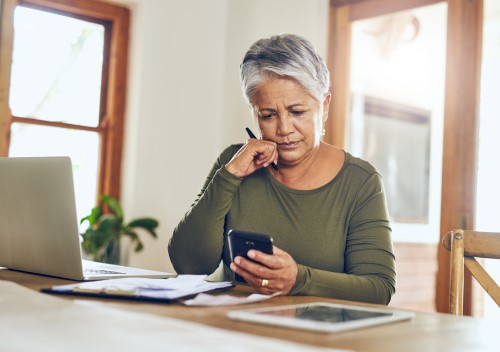 Woman sitting at desk looking at mobile device