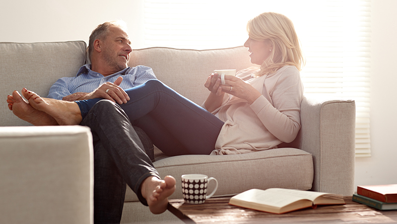 A man and woman sitting on a couch having a candid conversation