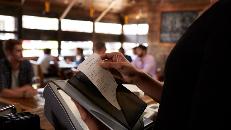 A waiter about to deliver the bill