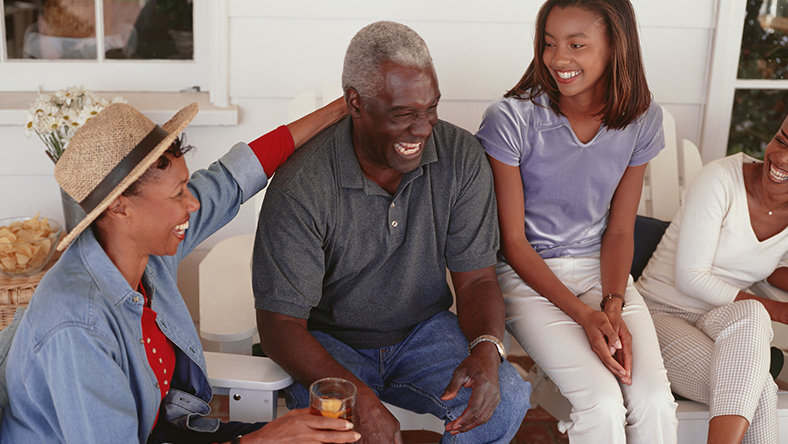 Family sitting on their porch laughing