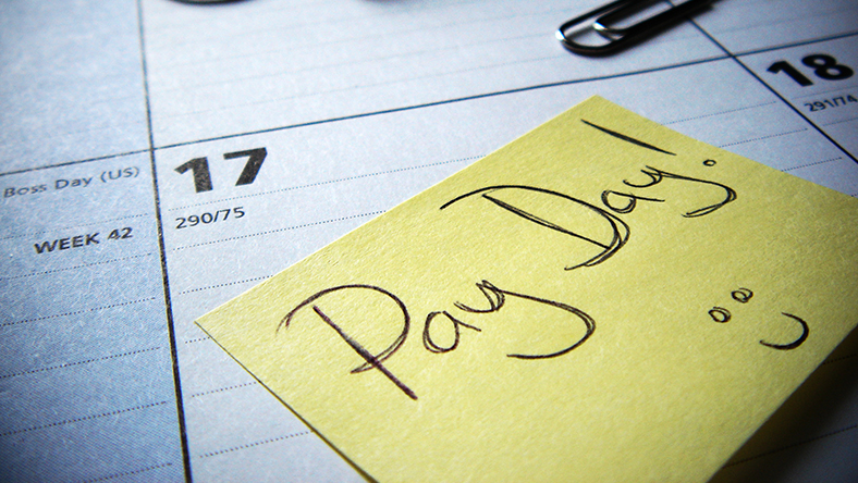 Post-it note on a calendar marking pay day