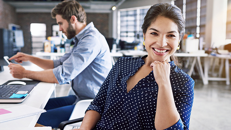 Woman smiling in an open office environment