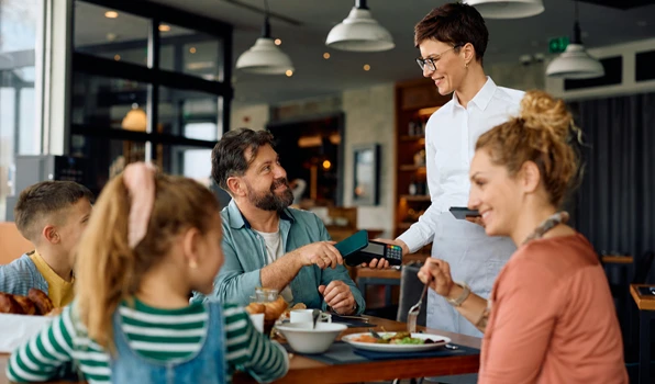 Customer using a debit card to pay for a meal at a restaurant, highlighting secure and convenient checking account purchases for everyday expenses.