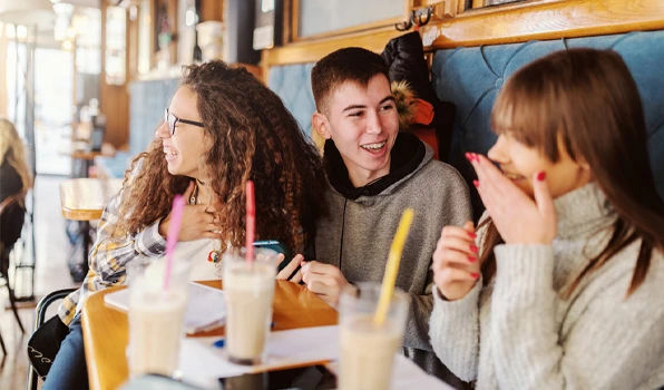 Group of students gathered at a café, illustrating budgeting, spending awareness, and money management tools that help track everyday expenses and financial goals.