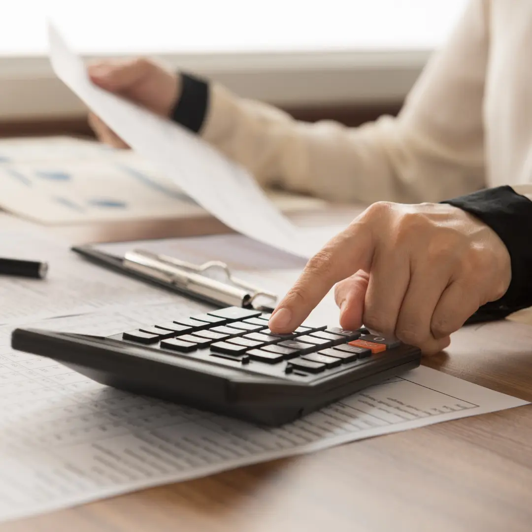 Close up of a woman's hand using a desktop calculator